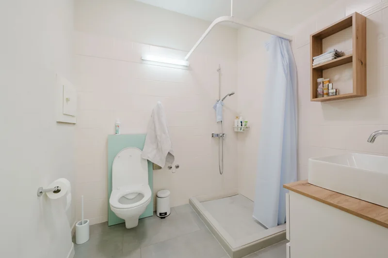 Salle d’eau claire avec douche et mobilier en bois